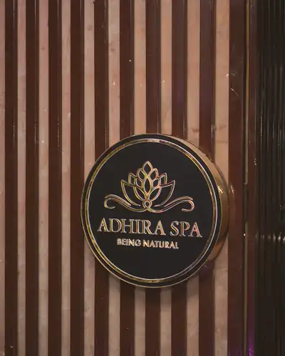 The Adhira Spa lotus sign on a wooden slatted wall