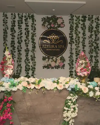 Adhira Spa reception with the gold lotus sign and fresh flowers